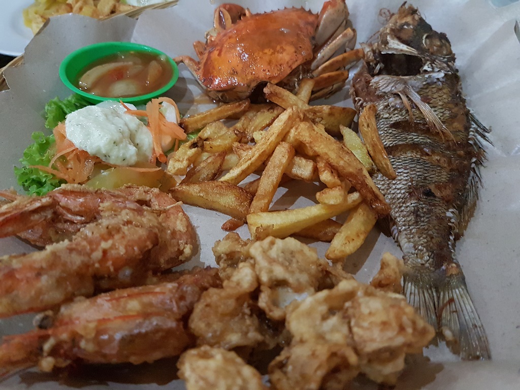 mand met gebakken patat en zeevruchten